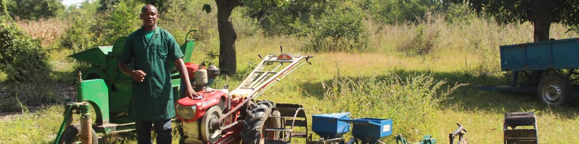 Eine Person, die neben einem Traktor steht.