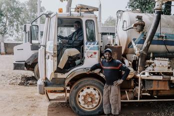 Deux hommes avec un camion évacuant des eaux usées.