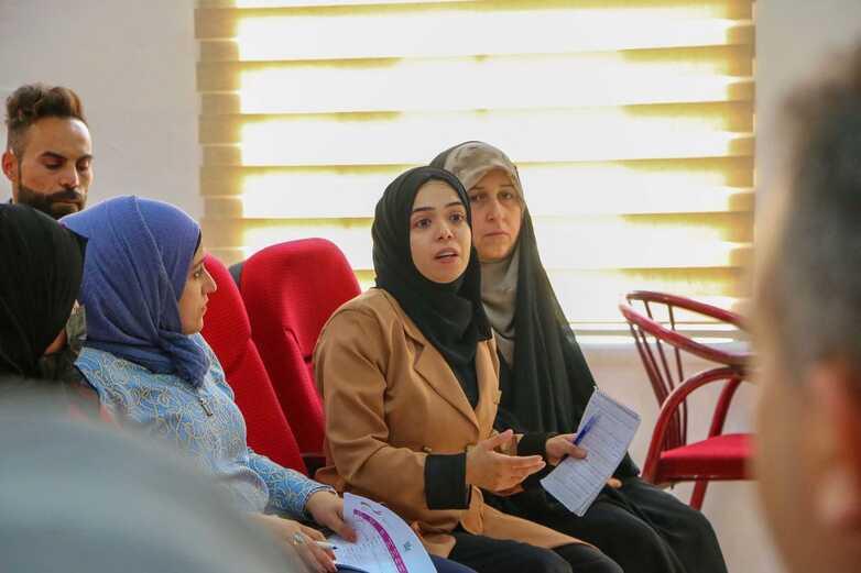 Four women and one man in a discussion group.