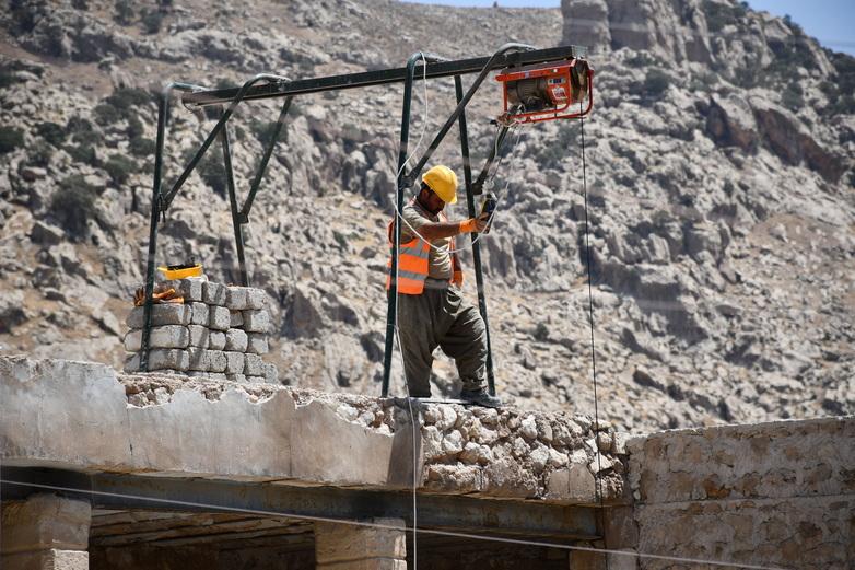 A construction worker operating a small crane.