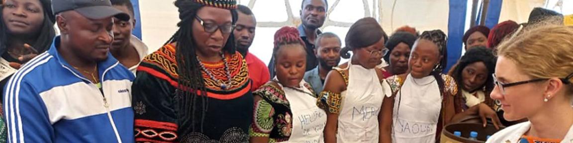 Menschen haben sich um einen Tisch versammelt und betrachten Kulturpilze.