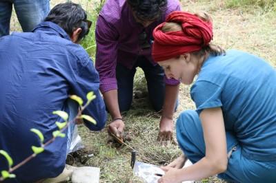 Eine Agrarforscherin nimmt Bodenproben, um die Bodenqualität zu untersuchen.
