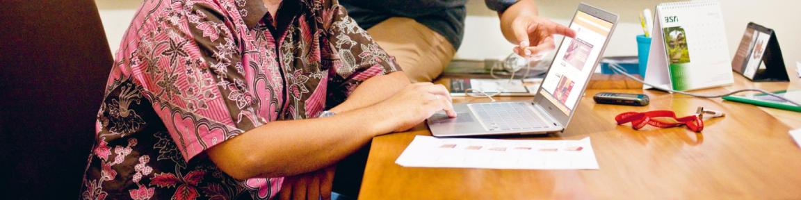Eine Frau sitzt an einem Schreibtisch mit einem Laptop.