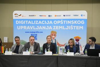 Eine Gruppe von Menschen sitzen vor einer Abbildung der Digitalisierung der Wirtschaft in der Europäischen Union.