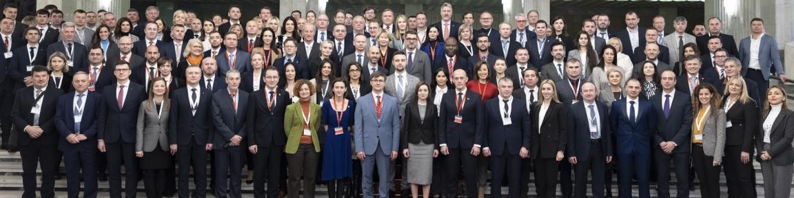 Eine große Gruppe Menschen in offizieller Kleidung posiert für ein Foto.