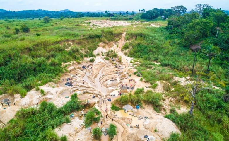 An aerial image of muddy terrain amid a green landscape.