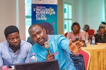 A man with a microphone explains something to another man at an exchange format for user-orientated administration services. Copyright: GIZ