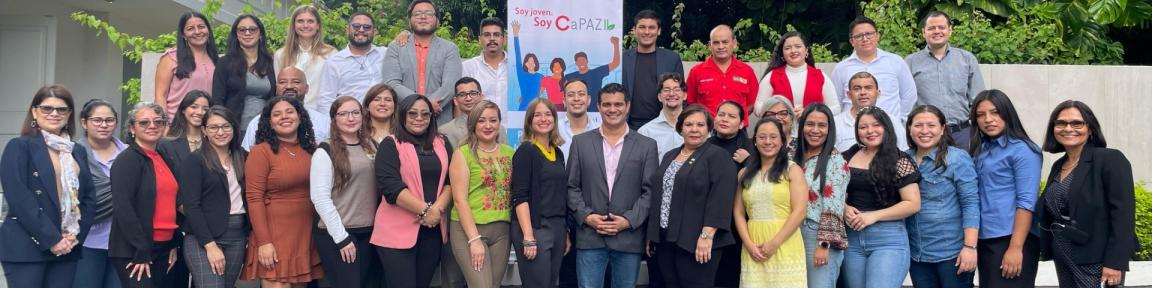 Projektteilnehmende stehen mit einem Projektaufsteller für ein Foto zusammen.