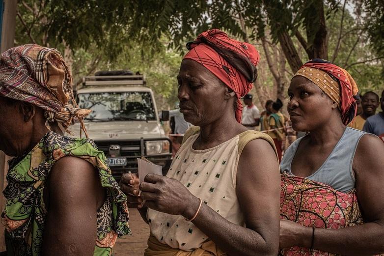 Menschen stehen in einer Schlange mit Dokumenten in der Hand. Copyright: GIZ / Raissa Karama