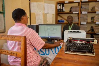 An official sitting in front of a PC. Administrative bodies working digitally.