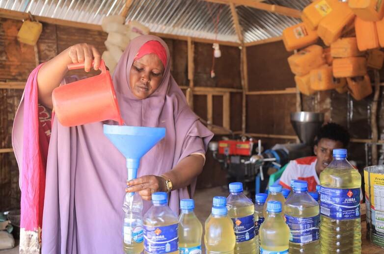 A woman bottles her coconut oil.