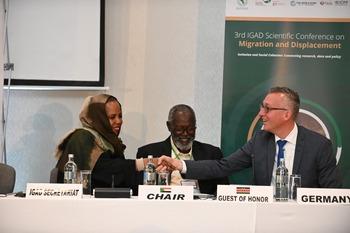 The German ambassador in Kenya and the director of the IGAD Health and Social Development Division shake hands at a conference.