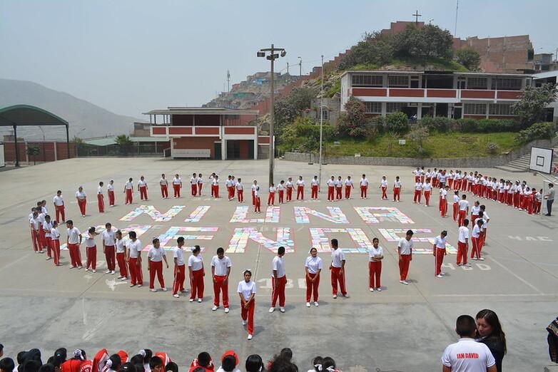 Escolares forman un corazón en el patio de un colegio alrededor del lema “Ni una menos”.