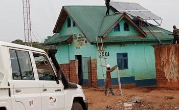Workers installing solar panels on the roof of the community radio station in Kamanyola, South Kivu.