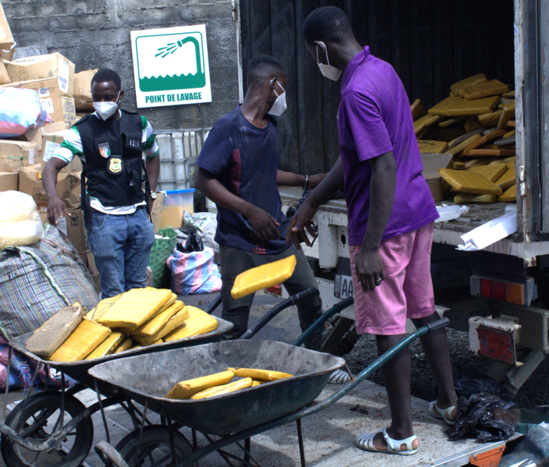 Three men unload confiscated cocaine.