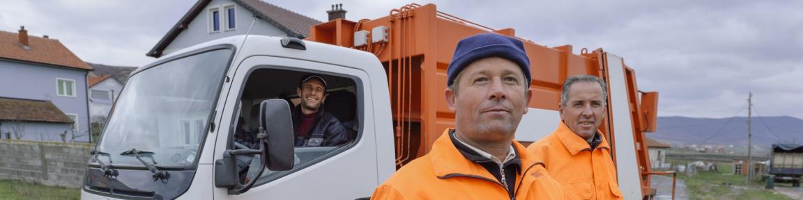 Drei Arbeitskräfte mit einem Kraftfahrzeug.