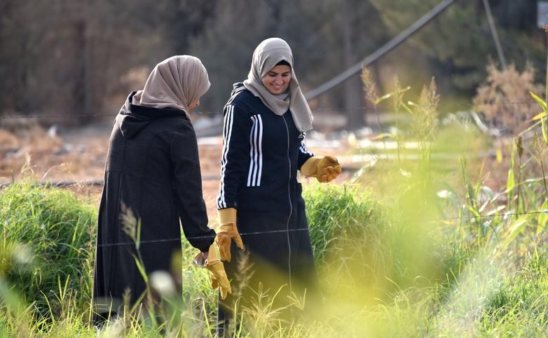 Two women taking part in a training course work in a field. © GIZ/Cannizzo