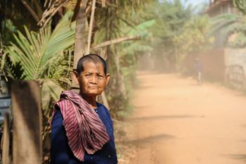An older woman standing in the street in Cambodia. Copyright: GIZ/Ursula Meissner