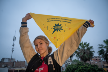 A girl holding up a scarf for the ‘Chamas en Acción’ programme.