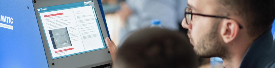 Zwei Personen schauen auf einen Bildschirm