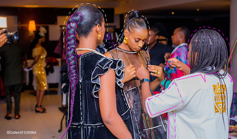 A designer adjusts the outfits of two models at a fashion show. Copyright: Collectif EGSINA