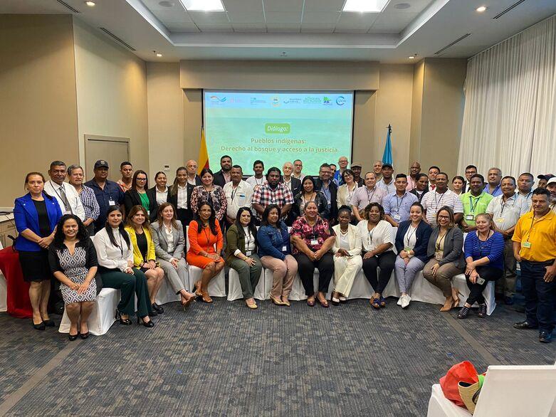 Zahlreiche Menschen stehen und sitzen bei einer Veranstaltung für ein Foto zusammen.