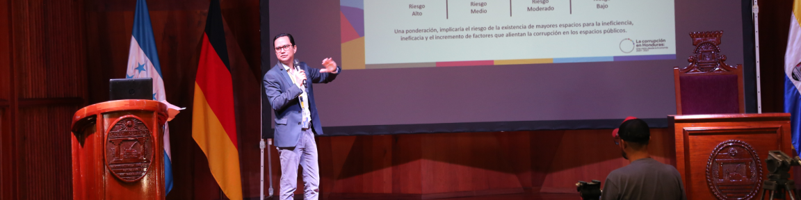 Ein Mann spricht bei einer Veranstaltung auf einer Bühne.