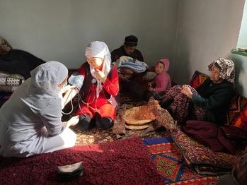 A family nurse during a routine postnatal home visit in a village.