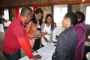 Cinq personnes sont en train de discuter devant des documents placés sur une table.