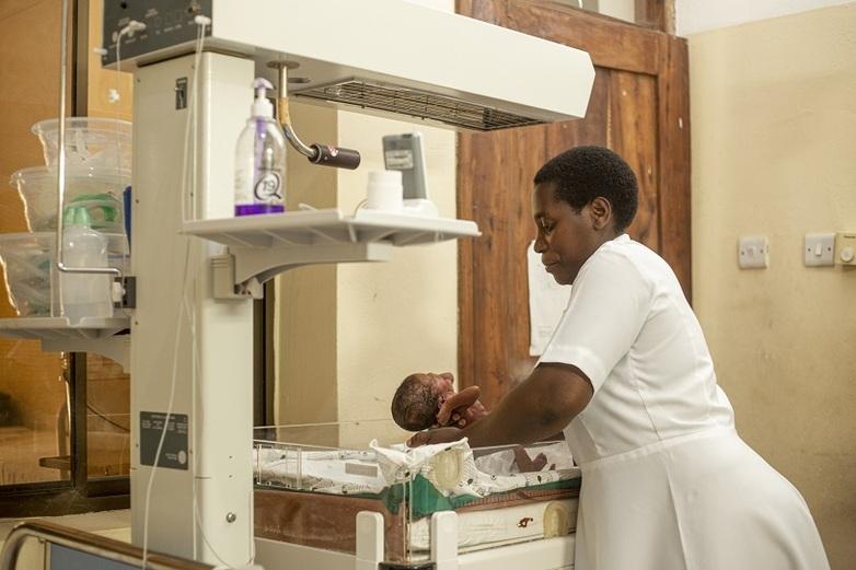 A medical professional cares for a newborn in the neonatal unit.