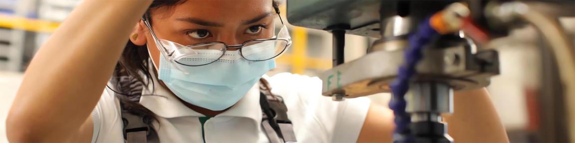 Una aprendiz maneja una máquina en una imprenta.