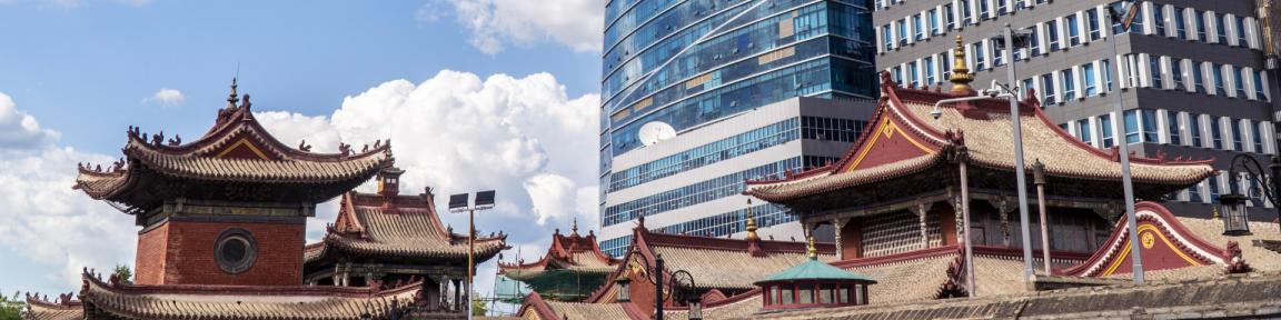 Traditionelle Häuser stehen vor modernen Wolkenkratzern in der Hauptstadt Ulan Bator der Mongolei.