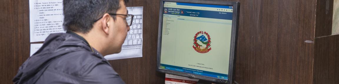 Eine Person sitzt an einem Computer, an dem die Seite einer Finanzbehörde geöffnet ist.