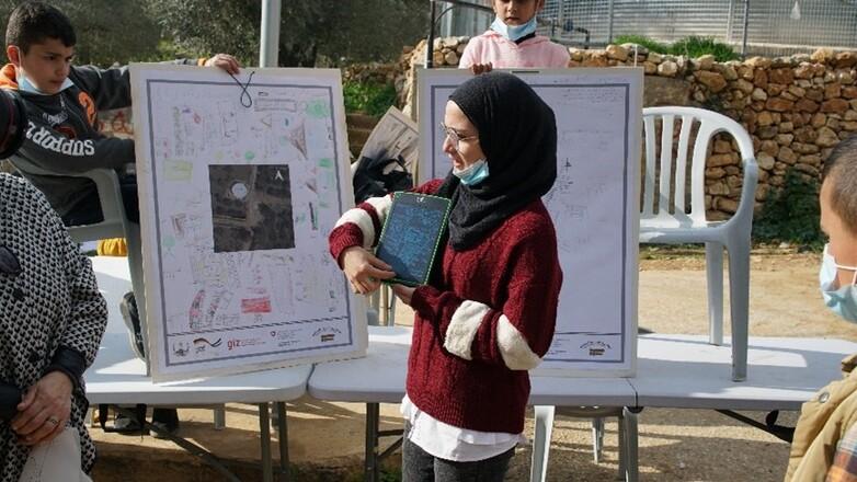 Eine Frau stellt ein Schaubild vor.