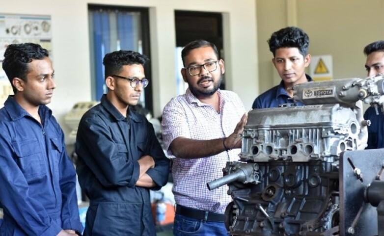 A group of men in front of a machine