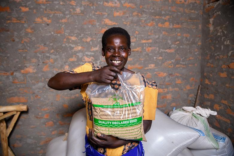 A woman in northern Uganda proudly displays a bag of quality declared seeds.