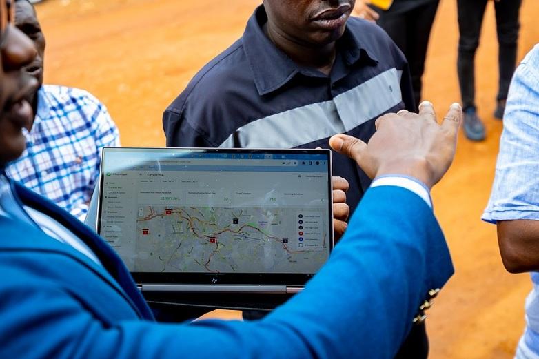 A person is holding a tablet displaying a digital map.