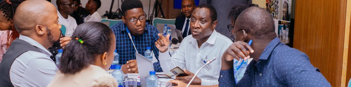 Die Menschen sitzen an Tischen zusammen und diskutieren.