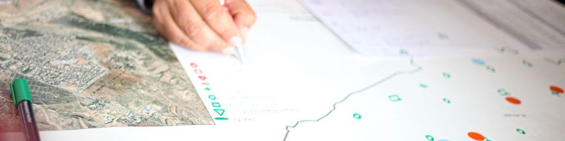 Eine Hand notiert etwas auf einer Karte.