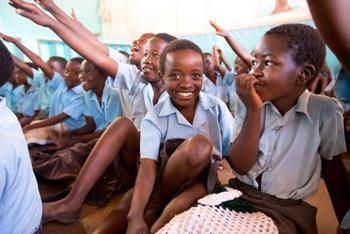 Malawi. A female student enthusiastically and confidently   takes part in a 'card collecting and clustering' exercise. © GIZ