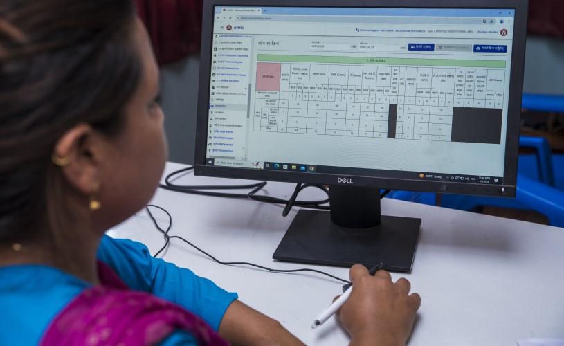 A hospital staff member using a computer to input data into Nepal's national Health Management Information System.