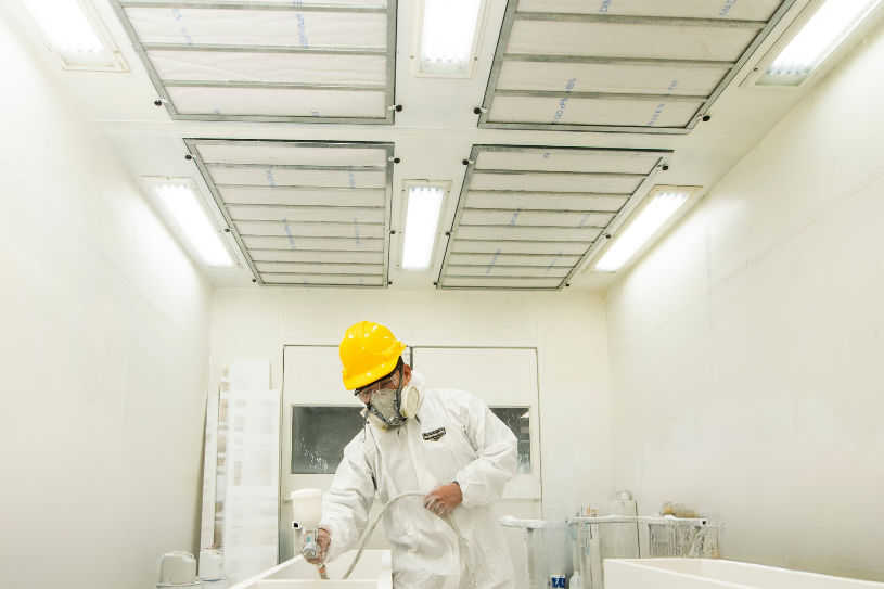 Ein Mann streicht Holz in einem Raum mit LED-Beleuchtung