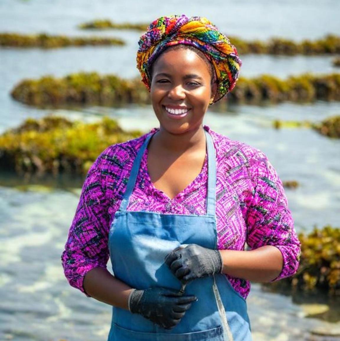 A woman harvesting seaweed from the sea.