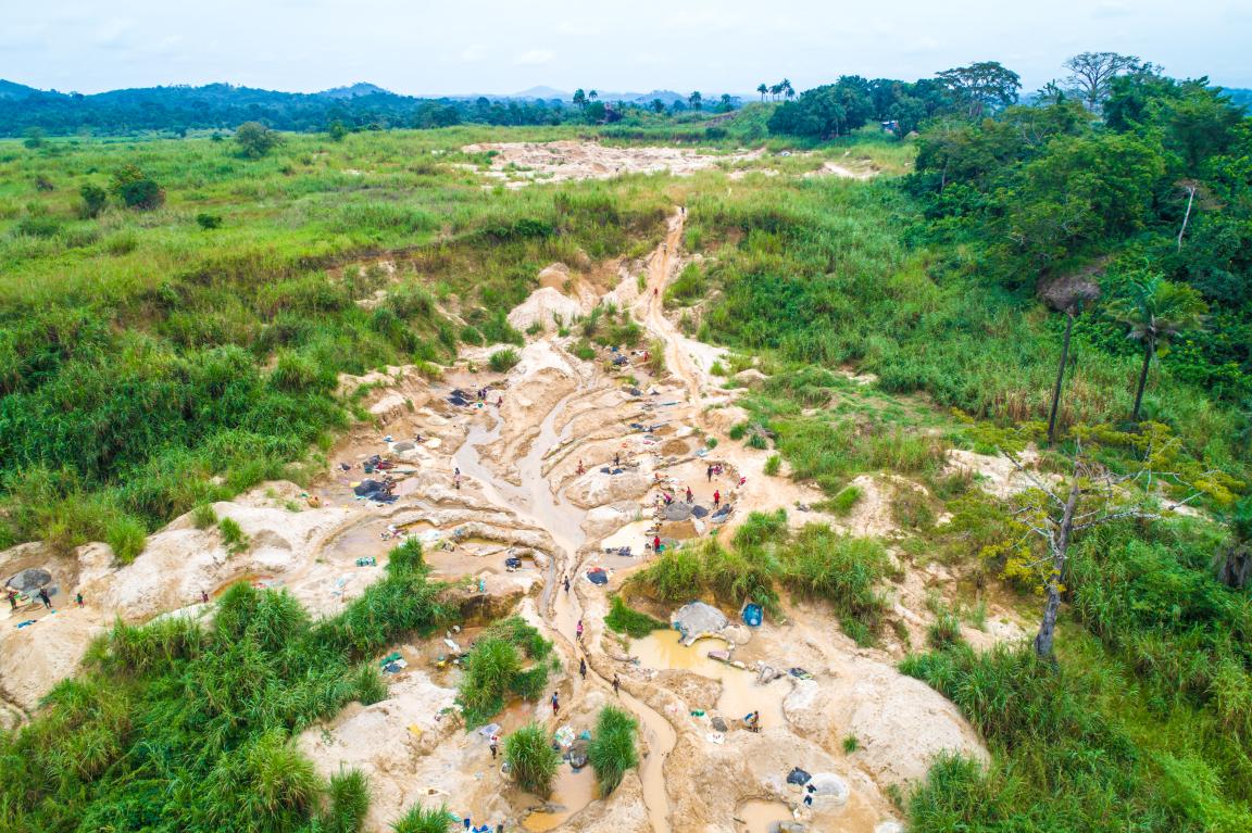 Eine Luftaufnahme eines schlammigen Geländes inmitten einer grünen Landschaft.