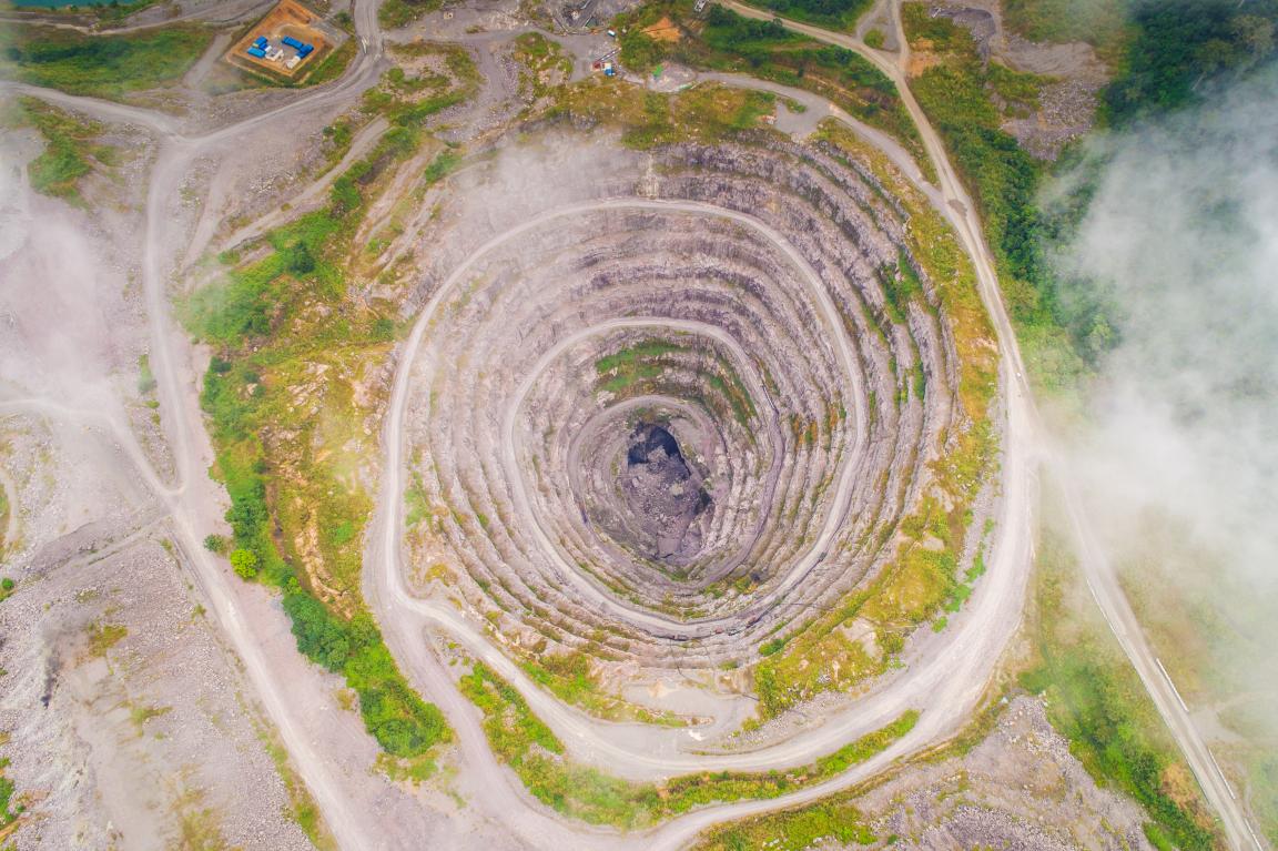 Aerial view of a rocky, spiral-shaped, open pit mine.