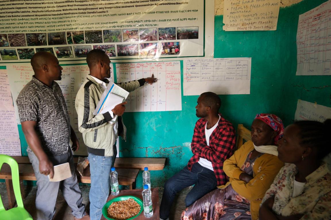 Pointing to a table of figures, the head of the cooperative shows his staff the past year’s results.
