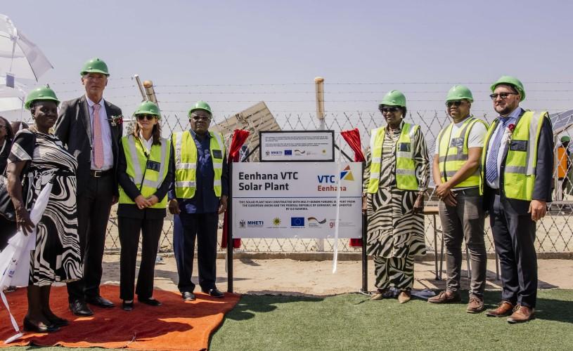 Dignitaries celebrate the inauguration of Eenhana Vocational Training Centre’s PV Solar Plant with flags in the background.