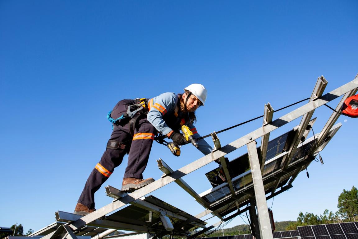 Uma funcionária a instalar painéis solares 