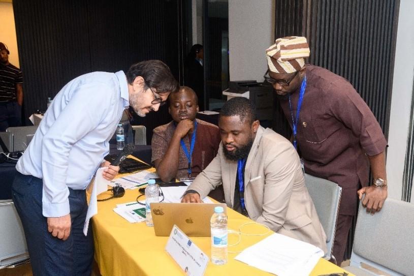 Partner sitzen während eines Workshops zusammen und schauen auf einen Laptop.