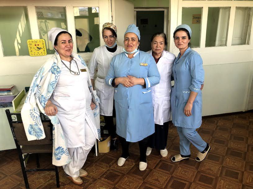 Fünf Ärztinnen und Krankenschwestern in Arbeitskleidung.